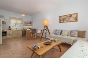 a living room with a couch and a table at Vitalis Residences - Rural Living in Péran Triovasálos