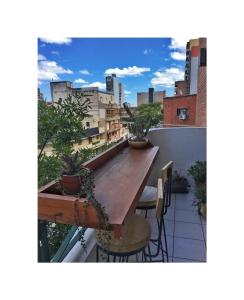 a balcony with a wooden table and chairs at Tucumán Suite Departamento equipado con excelente ubicación in San Miguel de Tucumán