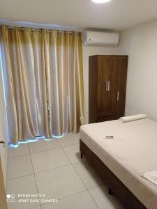 Schlafzimmer mit einem Bett, einer Kommode und Vorhängen in der Unterkunft Apart cómodo y seguro a pasos de todo 33 in Ciudad del Este