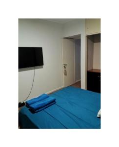 a bedroom with a blue bed with a flat screen tv at Tucumán Suite Departamento equipado con excelente ubicación in San Miguel de Tucumán