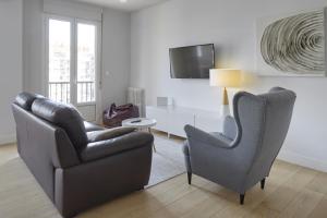 a living room with two chairs and a television at Aukera - Basque Stay in San Sebastián