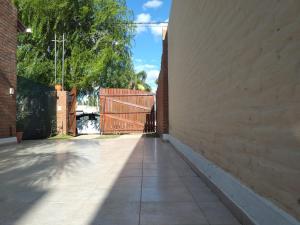 una pasarela vacía con una valla y una pared de ladrillo en Casa Con Pileta En Roldan en Roldán