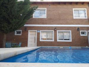 a swimming pool in front of a brick building at Casa Con Pileta En Roldan in Roldán