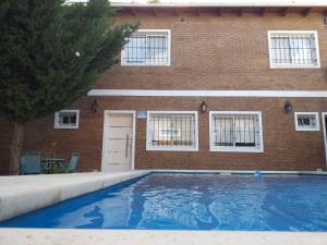 una piscina frente a un edificio de ladrillo en Casa Con Pileta En Roldan en Roldán