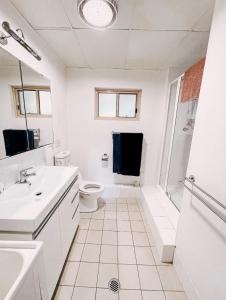 a white bathroom with a sink and a toilet at Oasis on the Hawkesbury - Water Views in Brooklyn