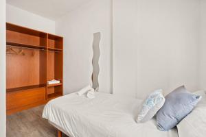 Cala LlongaにあるApartamento Sa Mesquida 9の白いベッドと青い枕のある寝室