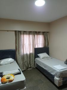 a bedroom with two beds and a window at Amplio y cómodo apartamento con bella vista en pleno centro in Ciudad del Este
