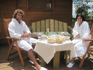 a man and woman sitting at a table with food at Spa in The Woods - B&B in Amirim in Amirim