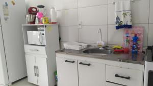 a small kitchen with a sink and a refrigerator at Quarto,em casa compartilhada in São José