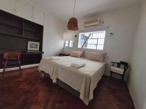 1 dormitorio con 1 cama grande y ventana en Casa Villanueva en Mendoza