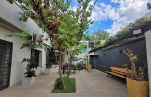 a patio with a bench and tables and trees at Casa Villanueva in Mendoza