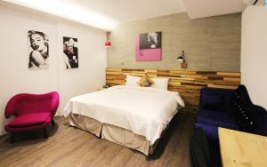 吉安的住宿－松石旅館，一间卧室配有一张床和一张红色椅子