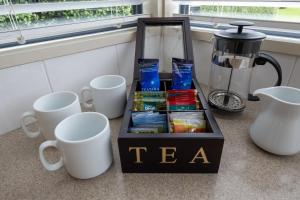 a tea box sitting on a table next to cups at *** LAKE VILLA 459 *** in Hanmer Springs +15 photos