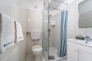 a bathroom with a toilet and a shower at Lena`s Beach House by HelloVacations in Albufeira