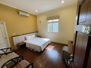 馬公市的住宿－居山水岸民宿，卧室配有白色的床和窗户。