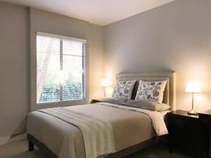 洛杉矶Perfect Apt near UCLA w Parking Gym Pool WIFI in Westwood B3的一间卧室，有一张床，两盏灯和一扇窗户