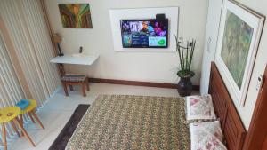 ein Wohnzimmer mit einem Fernseher an der Wand in der Unterkunft Apartamento em Barra do Piraí in Barra do Piraí