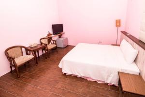 a bedroom with a bed and a desk and a computer at Coast Shan Shui B&B in Magong