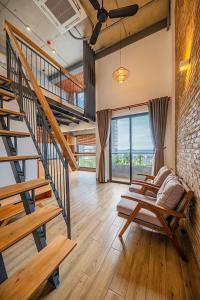 a living room with wooden floors and a staircase at Coast House Boutique Hotel in Nha Trang