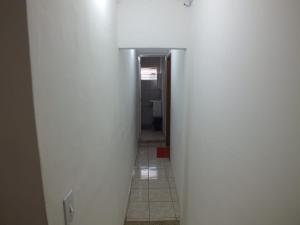 um corredor com paredes brancas e piso em azulejo em Hospedagem Henri Dunant em São Paulo