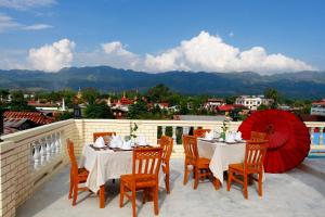 een patio met tafels en stoelen op een balkon bij Sandalwood Hotel in Nyaung Shwe