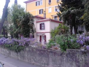 a house with purple flowers in front of a wall at Room Sarah in Rijeka