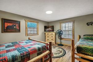 1 dormitorio con 2 camas, vestidor y 2 ventanas en Mama Bear's Retreat, en Sevierville