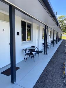 a row of tables and chairs on the side of a building at The Seaview Tavern Motel in Woolgoolga