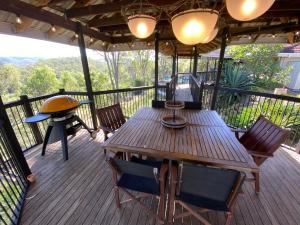 a wooden deck with a wooden table and chairs at KooralBnB in Kooralbyn