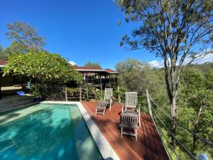 two chairs sitting on a deck next to a swimming pool at KooralBnB in Kooralbyn