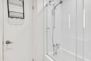 a shower with a glass door with a shower head at Le Lightroom by Gestion ELITE in Mont-Tremblant +30 photos