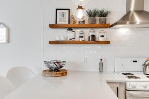 a white kitchen with a counter top and a stove at Le Lightroom by Gestion ELITE in Mont-Tremblant