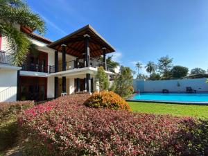 a house with a garden and a swimming pool at Christima Residence in Negombo