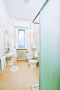 een badkamer met 2 toiletten, een wastafel en een douche bij Hotel Holiday Park in Bellaria-Igea Marina
