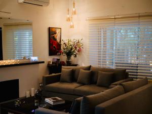 uma sala de estar com um sofá e uma mesa em Frangipani Suite em Nova Deli