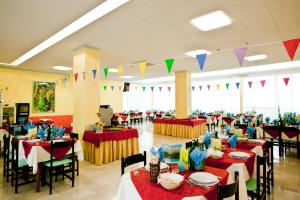 un salón de banquetes con mesas, sillas y banderas en Hotel Holiday Park, en Bellaria-Igea Marina