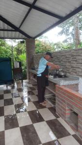 un hombre cocinando en una estufa en una cocina al aire libre en verde menta casa campestre en Rivera