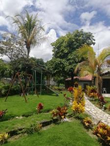 um jardim com um baloiço e um parque infantil em verde menta casa campestre em Rivera