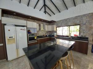 verde menta casa campestre في ريفيرا: مطبخ مع كونتر اسود توب وثلاجة