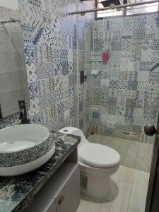 a bathroom with a white toilet and a sink at verde menta casa campestre in Rivera