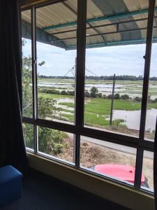 Habitación con ventana con vistas a un campo inundado en Putat Gajah Villa PASIR MAS en Pasir Mas