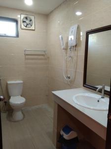 a bathroom with a toilet and a sink and a mirror at Putat Gajah Villa PASIR MAS in Pasir Mas