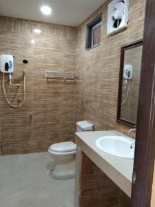 y baño con aseo, lavabo y ducha. en Putat Gajah Villa PASIR MAS en Pasir Mas