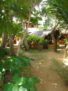 a group of trees in front of a building at Natural Cabanas in Tangalle