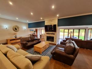 a living room with leather furniture and a fireplace at 391 Vaal de Grace Golf Estate, Parys in Parys