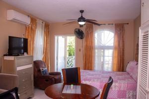 a bedroom with a bed and a table and a tv at Elegant Condo Awesome View in Ocho Rios