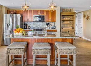 a kitchen with a large island with bar stools at Honua Kai 215 2 Bedroom 2 Bath condo in Lahaina