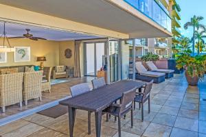 a patio with a table and chairs and a living room at Honua Kai 215 2 Bedroom 2 Bath condo in Lahaina