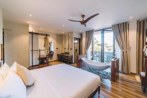 a bedroom with a bed and a tub and a bathroom at Zen Valley Dalat in Da Lat