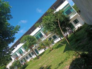 a large white building with trees in front of it at Pousada Vale Do Aijalom in Cabo Frio